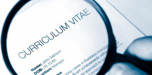 An image of a CV with a magnifying glass placed over it.