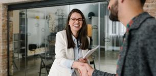 Woman shaking hands with a male: New Year, new job.