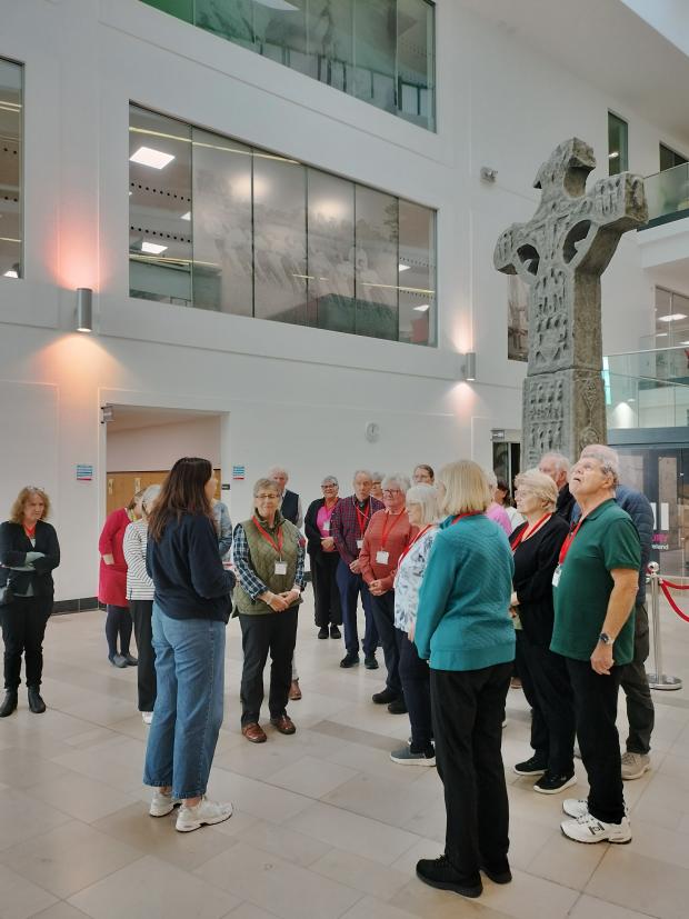 A PRONI staff member speaking to a group of visitors in the PRONI atrium