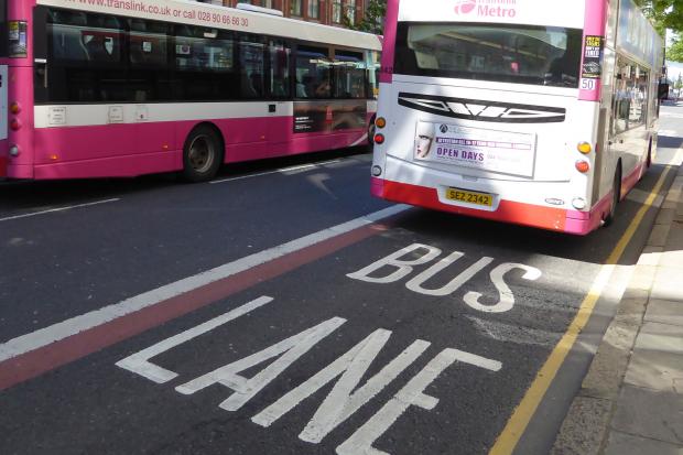 A bus travelling in a city centre kerbside bus lane